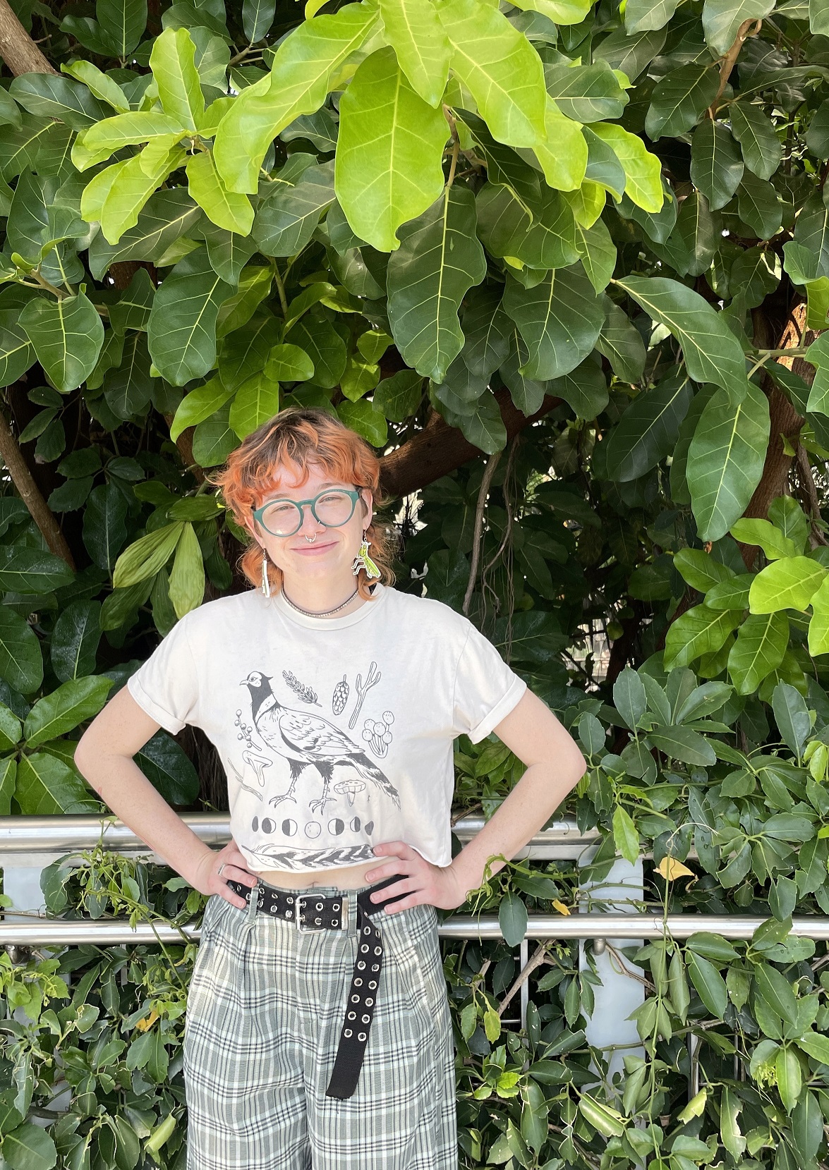 Student stands in front of plants 