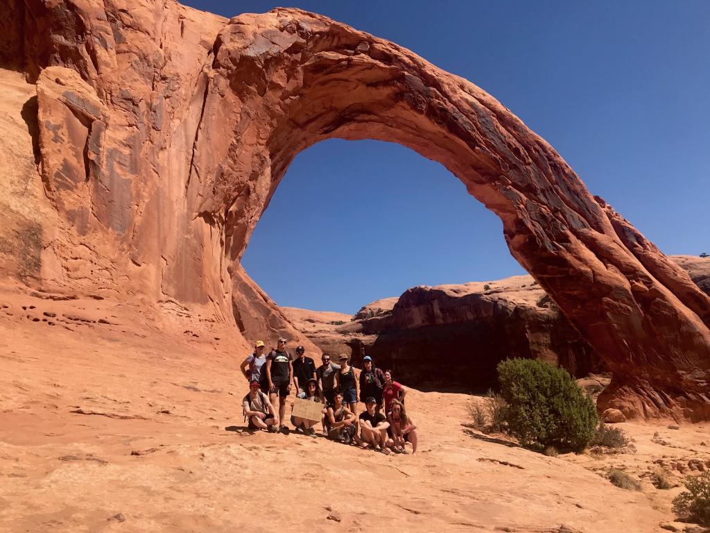 Students standing in front of desert arch
