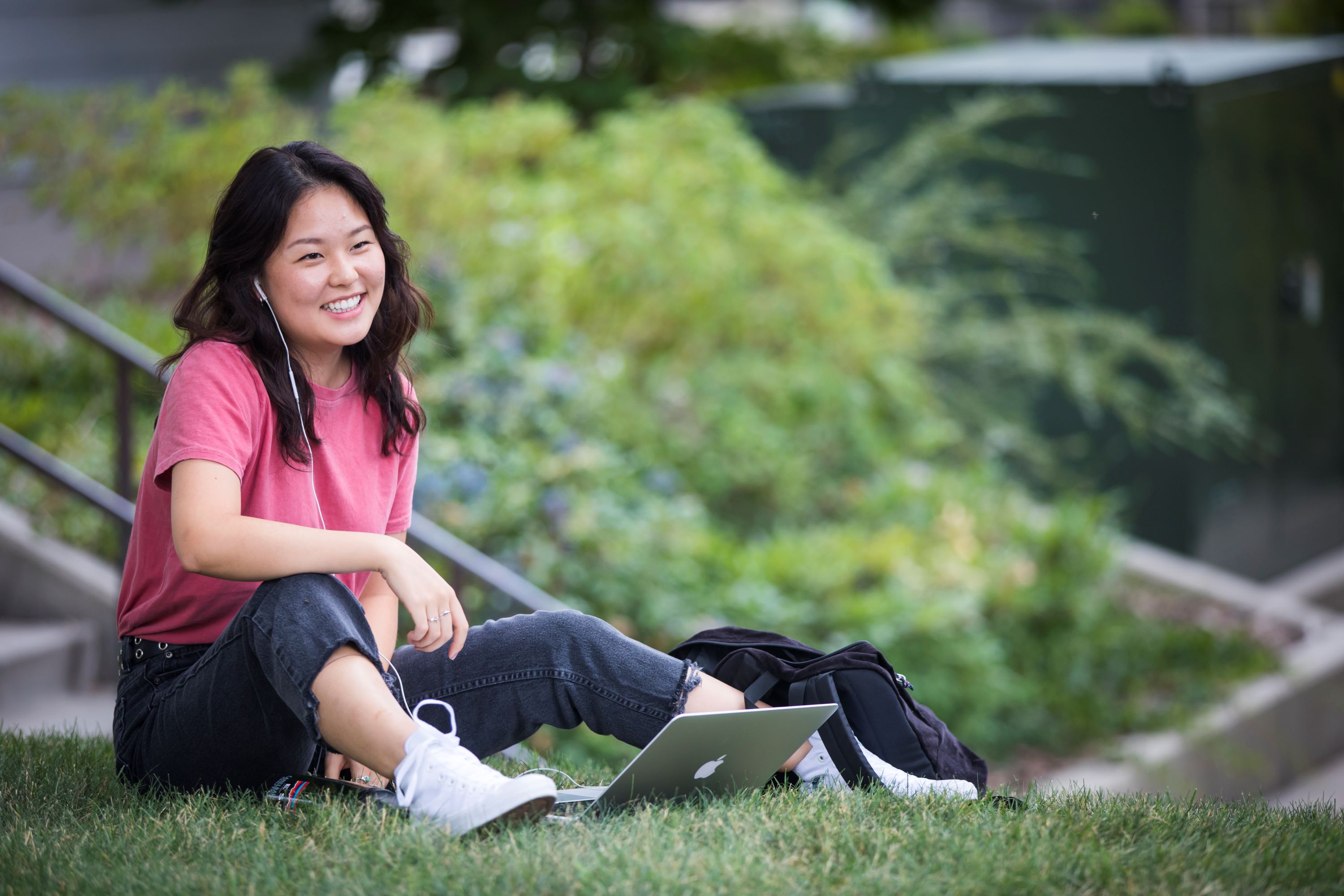 student sitting on the grass smiling